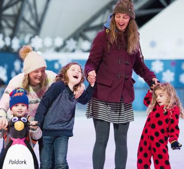 Mums and kids laughing as they ice skate